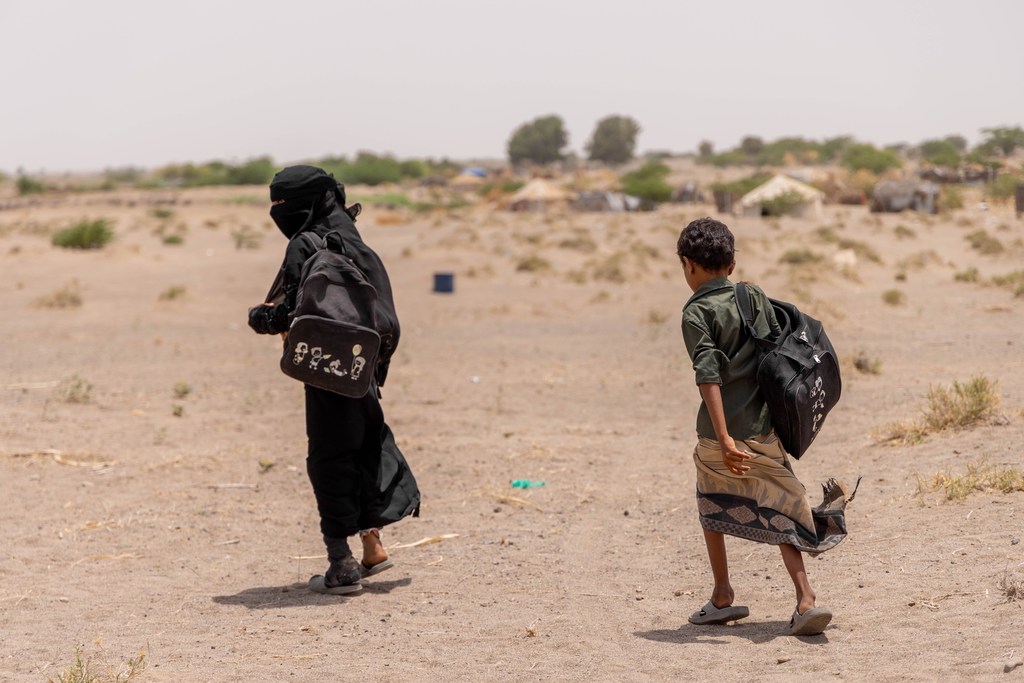 A girl and her brother walk home after attending classes at a UNICEF-supported educational tent. Millions of children in Yemen are out of school due to displacement and conflict-damaged schools. (file photo)
